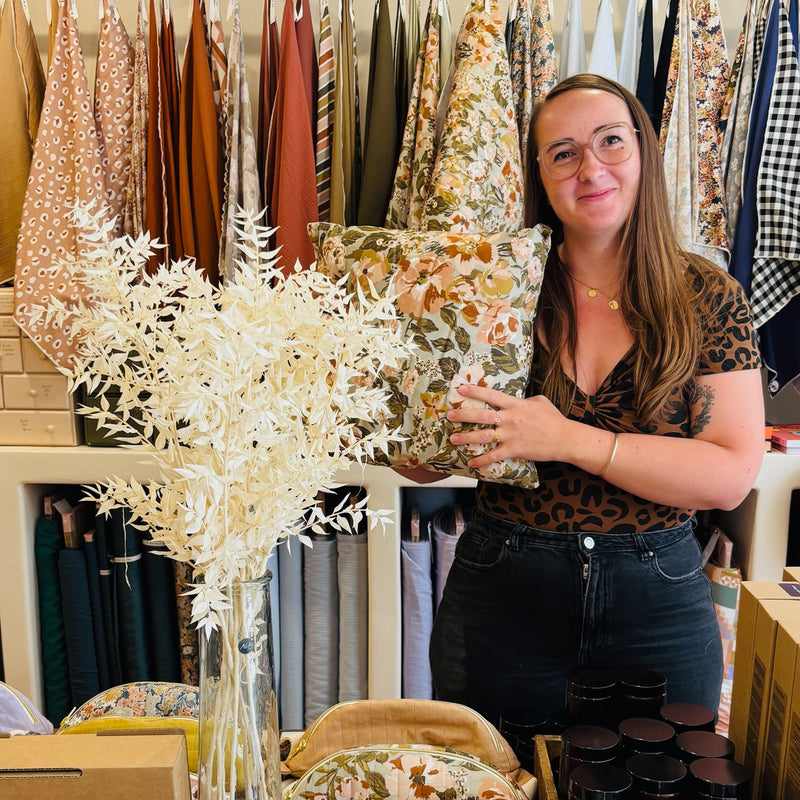 Cliente ayant réalisé son premier coussin à la machine à coudre lors d'un atelier La Maison Naïve