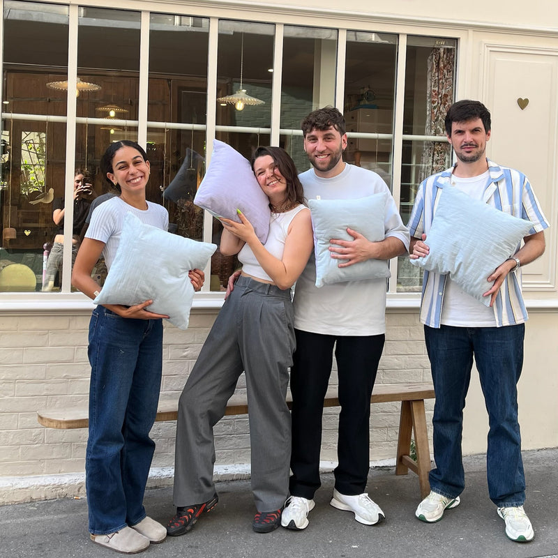 Participants à un atelier couture débutant à La Maison Naïve présentant les coussins réalisés pendant le cours